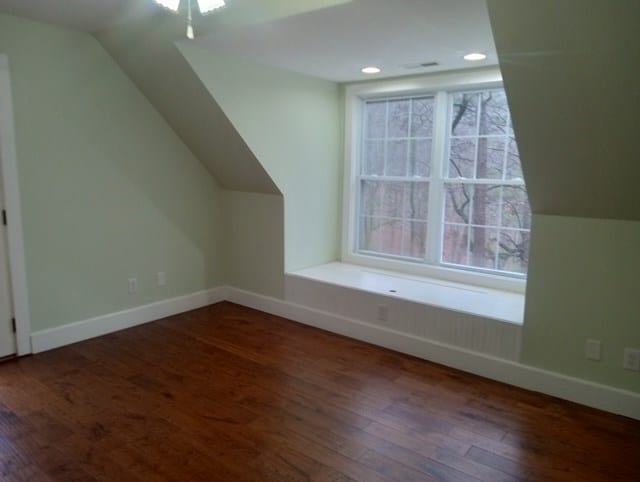 bonus room featuring lofted ceiling and dark hardwood / wood-style flooring