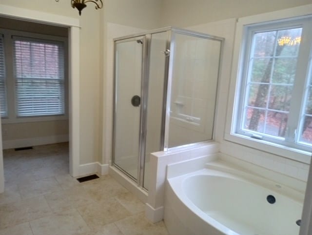 bathroom featuring separate shower and tub and a notable chandelier