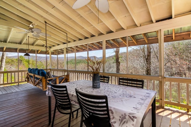 wooden terrace with ceiling fan, outdoor dining area, a mountain view, and a gazebo