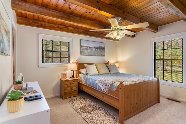 bedroom with multiple windows, light colored carpet, wood ceiling, beam ceiling, and baseboards