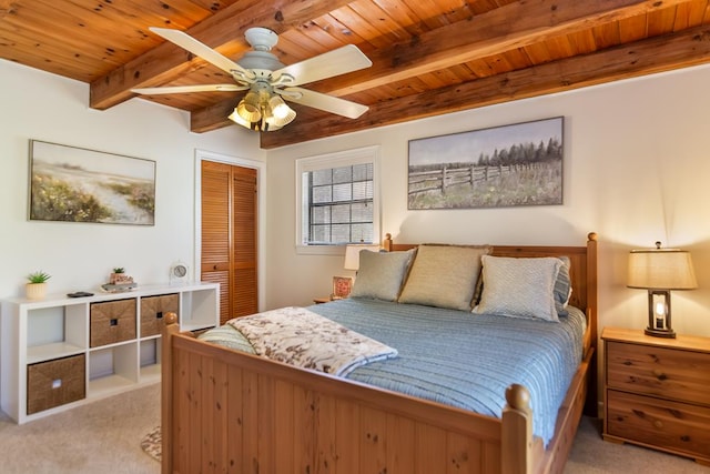 carpeted bedroom with wooden ceiling, beam ceiling, a closet, and ceiling fan