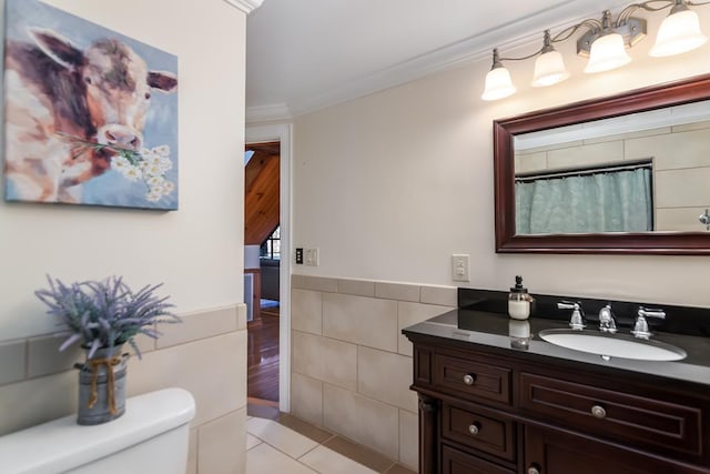 bathroom featuring tile walls, toilet, tile patterned floors, vanity, and ornamental molding