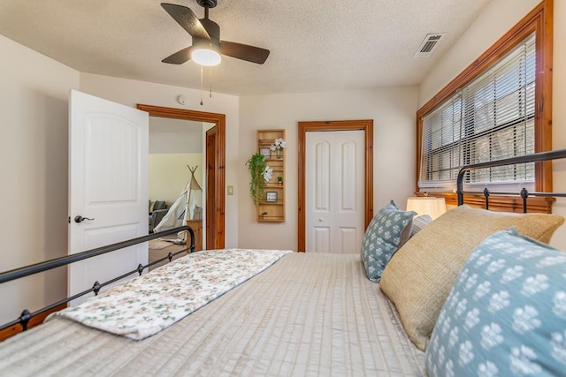 bedroom featuring a closet, a textured ceiling, and a ceiling fan