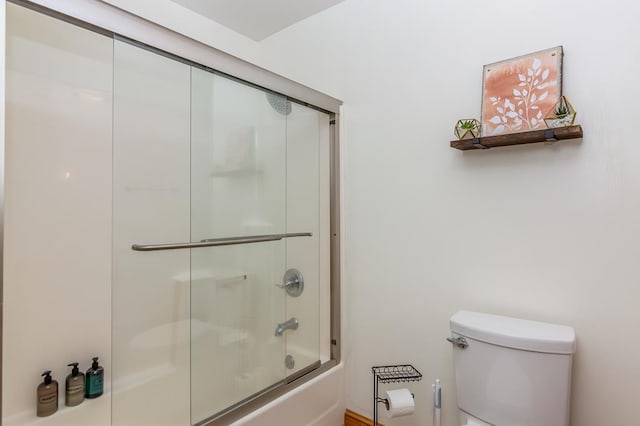 bathroom featuring toilet and combined bath / shower with glass door