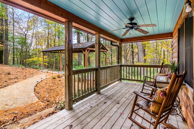 wooden terrace featuring a gazebo and ceiling fan