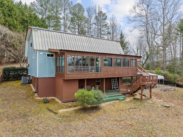 back of property with central air condition unit, a gambrel roof, metal roof, and a sunroom