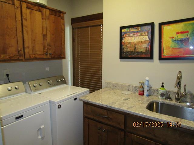 laundry room featuring cabinets, washer and dryer, and sink