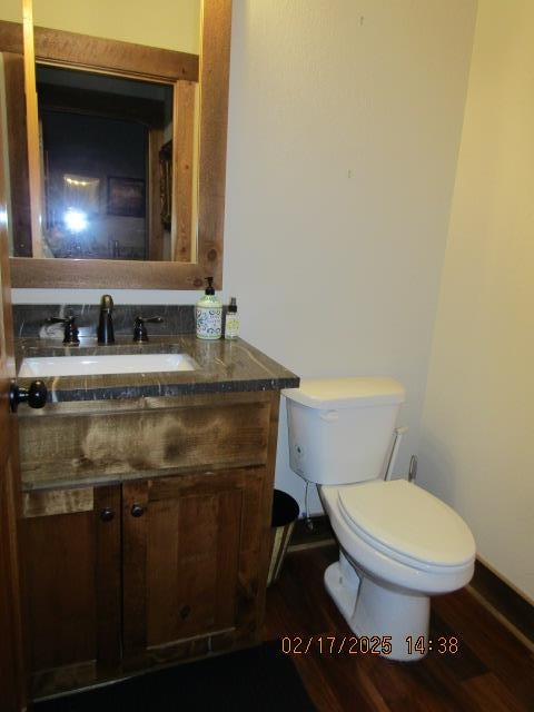 bathroom featuring toilet, wood-type flooring, and vanity