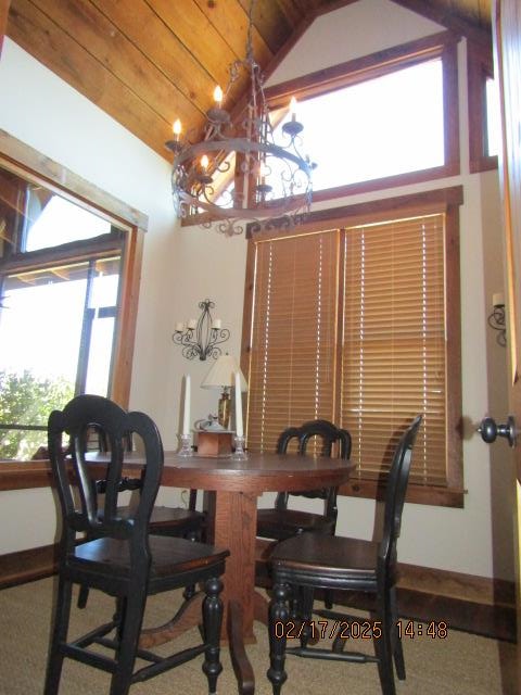 dining area featuring an inviting chandelier, vaulted ceiling, and wood ceiling