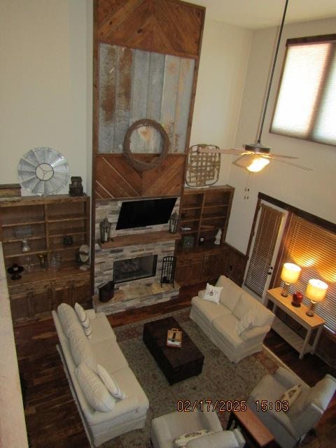 living room with a fireplace, ceiling fan, and hardwood / wood-style floors