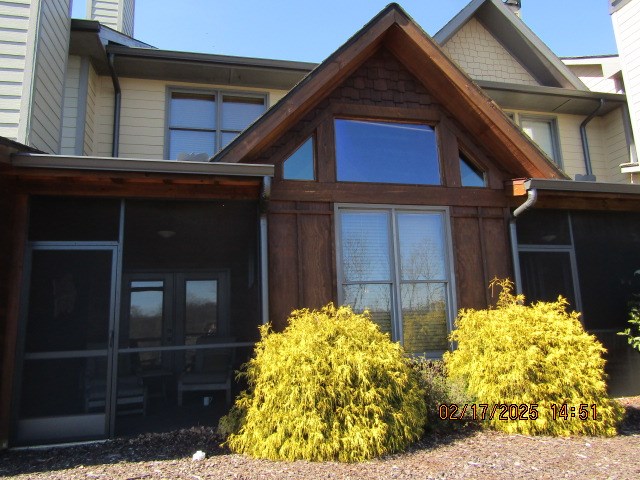 view of side of home with french doors and a sunroom