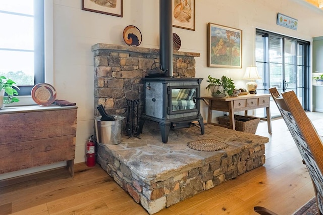 details with a fire extinguisher, wood finished floors, and a wood stove