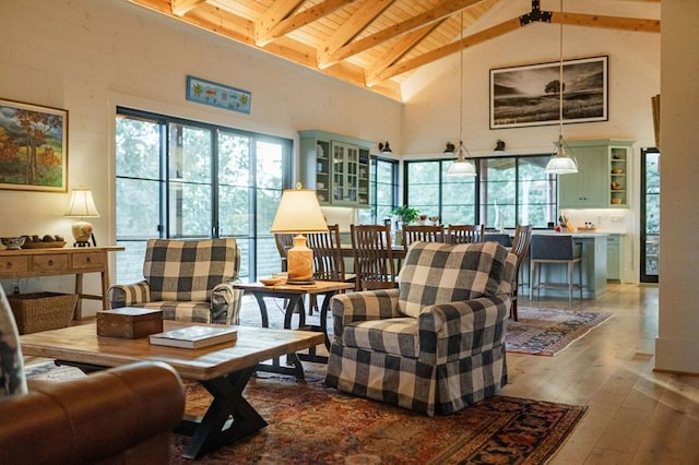 living room featuring beamed ceiling, high vaulted ceiling, wooden ceiling, and hardwood / wood-style flooring