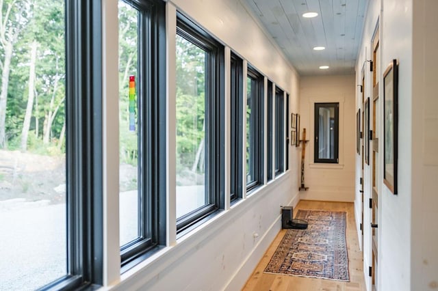 corridor featuring recessed lighting, baseboards, and wood finished floors