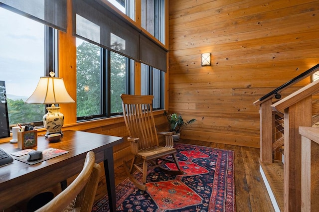 sitting room with wood finished floors, wood walls, and stairs