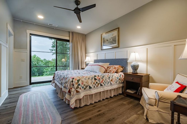 bedroom featuring visible vents, dark wood-style flooring, wainscoting, access to outside, and a decorative wall