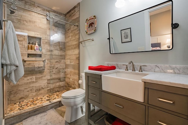 full bathroom featuring a stall shower, toilet, and vanity