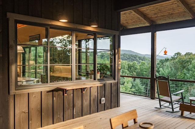 sunroom featuring a forest view