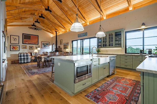 kitchen featuring stainless steel appliances, plenty of natural light, green cabinets, and light wood-style flooring