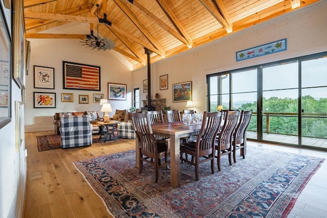 dining space with beamed ceiling, high vaulted ceiling, wood ceiling, and light wood-style flooring