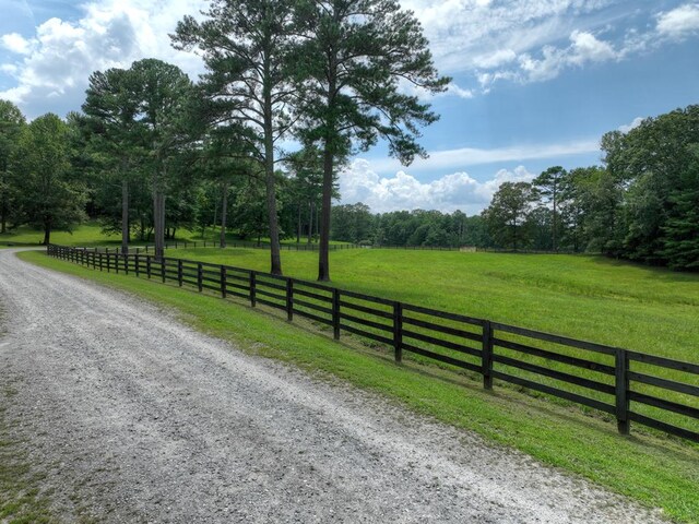 view of gate featuring a yard, a rural view, and fence