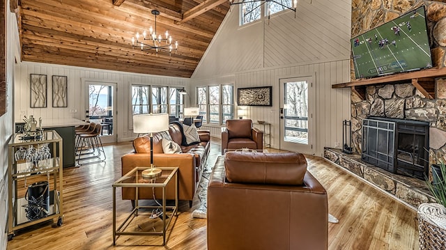 living room with high vaulted ceiling, hardwood / wood-style flooring, an inviting chandelier, wooden ceiling, and a fireplace