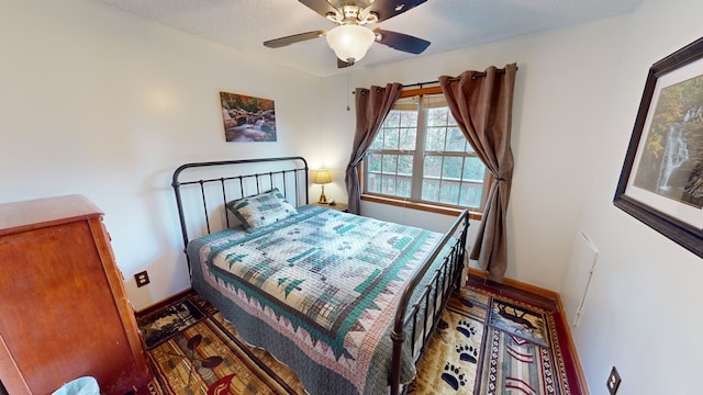 bedroom featuring hardwood / wood-style flooring, a textured ceiling, and ceiling fan