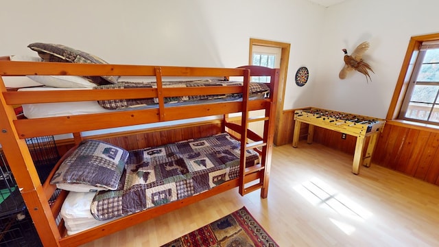 bedroom with light hardwood / wood-style flooring and wood walls