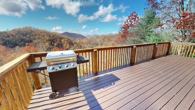 wooden deck with area for grilling and a mountain view