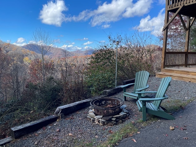 view of yard with a deck with mountain view and a fire pit