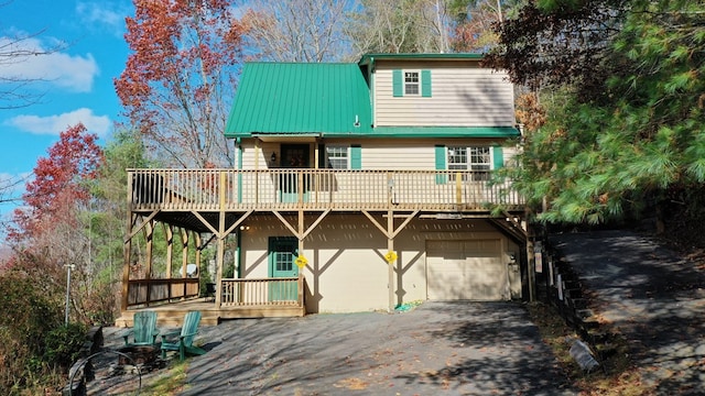 front of property with a wooden deck and a garage