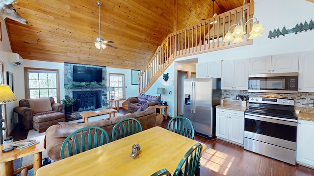 kitchen featuring a wall unit AC, light stone countertops, white cabinets, and appliances with stainless steel finishes