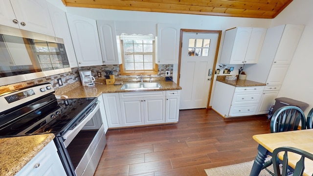 kitchen with sink, light stone counters, white cabinets, stainless steel appliances, and backsplash