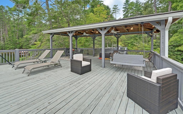 wooden deck with an outdoor hangout area and ceiling fan