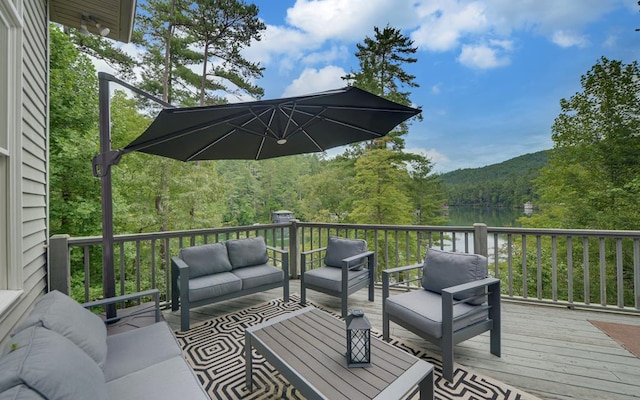 wooden terrace featuring an outdoor living space and a water view