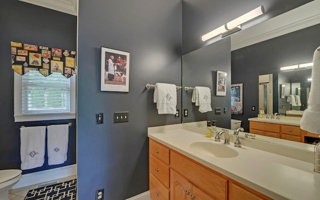 bathroom featuring tile patterned flooring, vanity, crown molding, and toilet