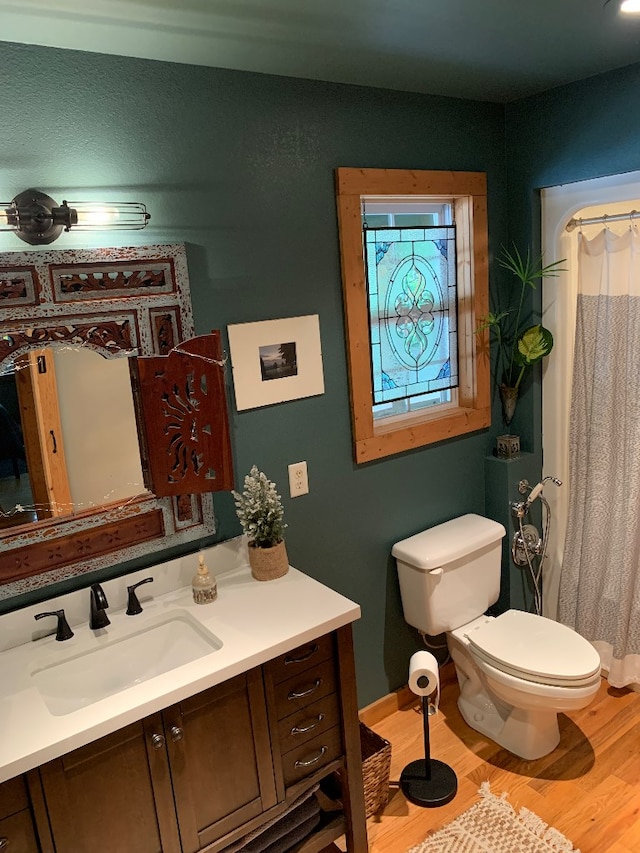 bathroom featuring vanity, hardwood / wood-style floors, a shower with shower curtain, and toilet