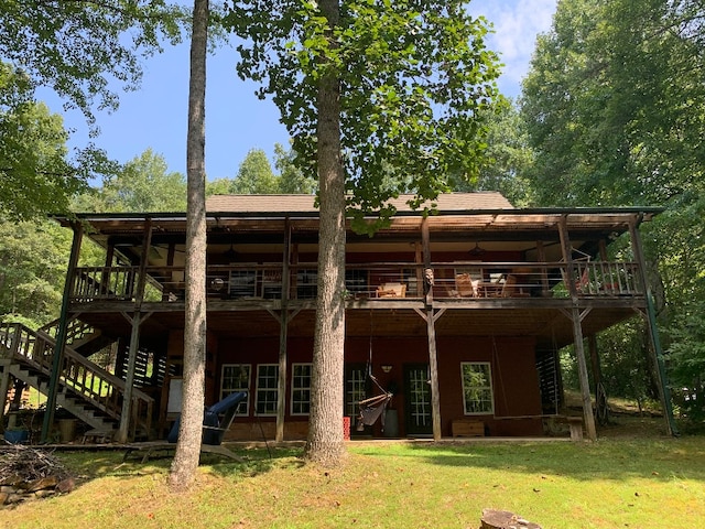 back of property featuring a wooden deck and a yard