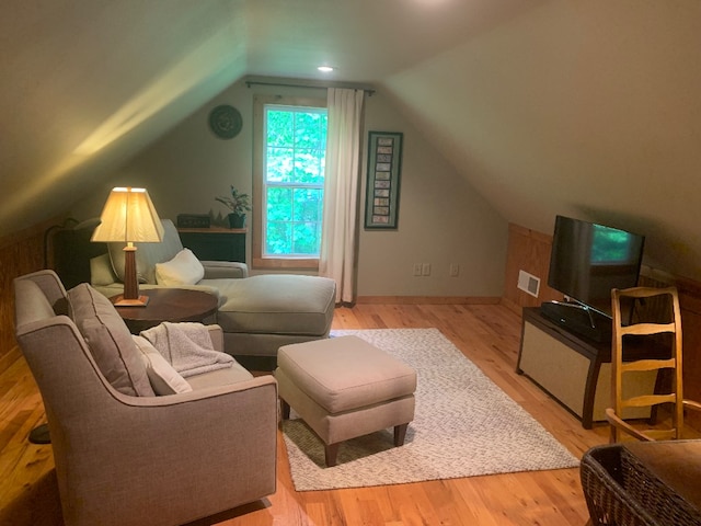 living room with light hardwood / wood-style flooring and vaulted ceiling