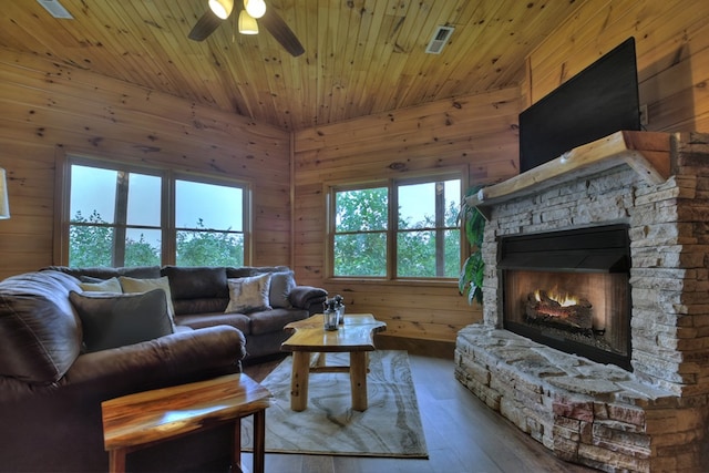 living room featuring a ceiling fan, wood ceiling, wooden walls, and wood finished floors