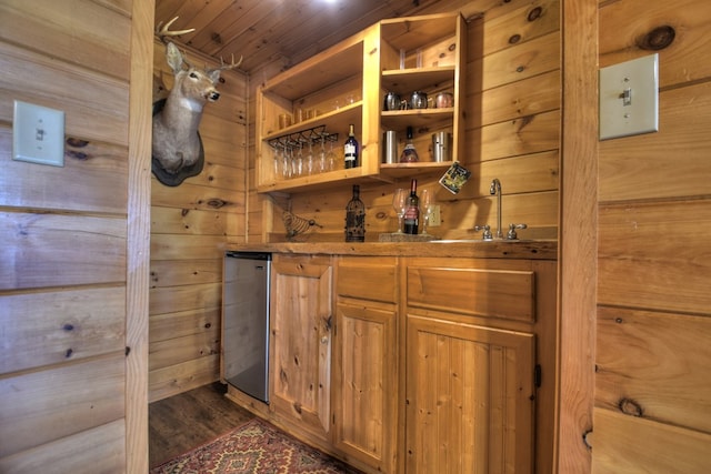 interior space featuring wood walls, a dry bar, a sink, dark wood-style floors, and wood ceiling