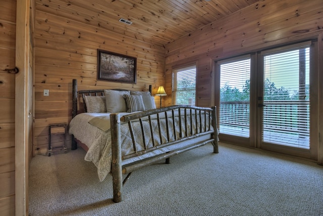 carpeted bedroom featuring access to exterior, wooden ceiling, and wood walls