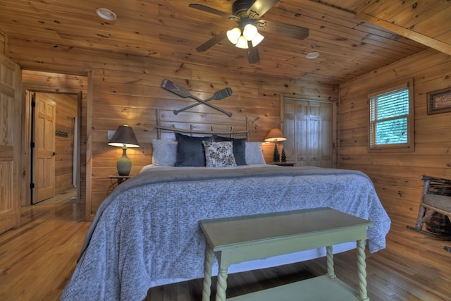 bedroom featuring wooden ceiling, wooden walls, and wood finished floors