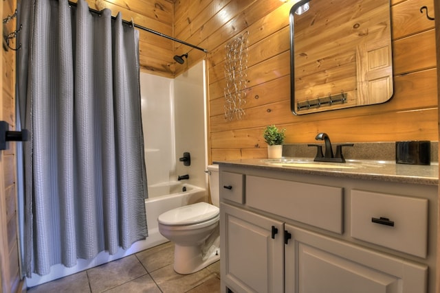 full bathroom featuring tile patterned flooring, vanity, wood walls, toilet, and shower / bath combo with shower curtain