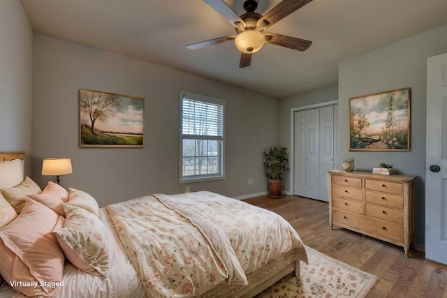 bedroom with light wood-type flooring, ceiling fan, baseboards, and a closet