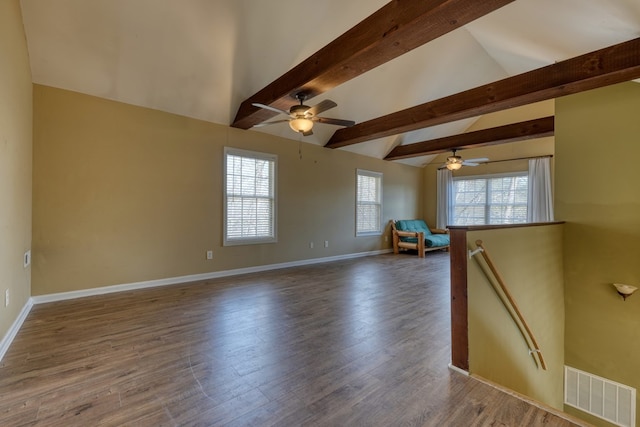 unfurnished room featuring lofted ceiling with beams, ceiling fan, wood finished floors, visible vents, and baseboards