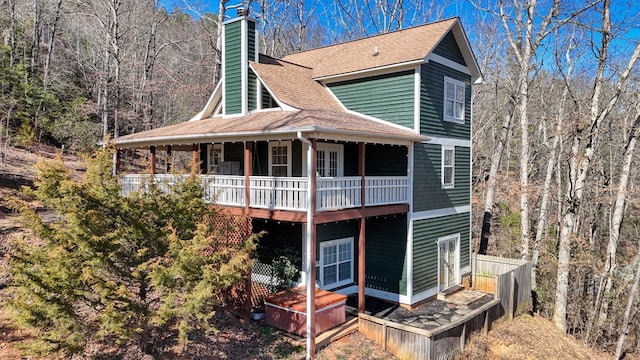 exterior space with a shingled roof and a chimney