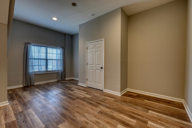 unfurnished room featuring recessed lighting, baseboards, and wood finished floors