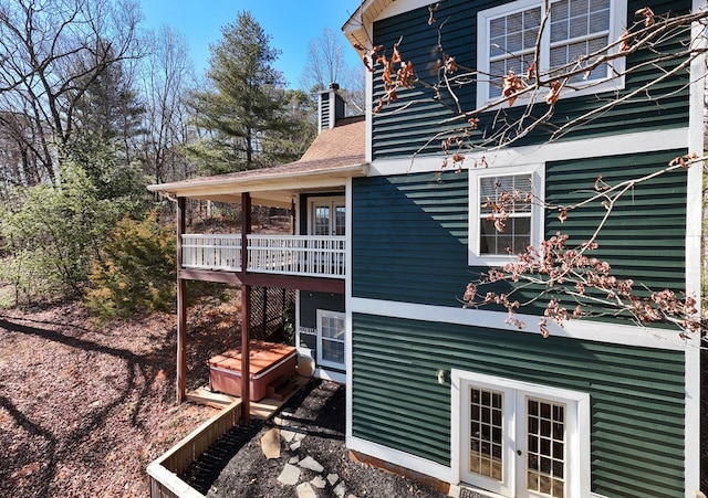 view of home's exterior featuring french doors and roof with shingles