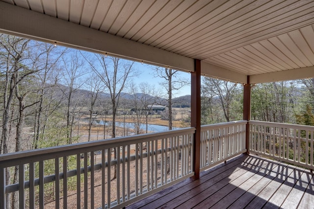 wooden terrace with a water and mountain view